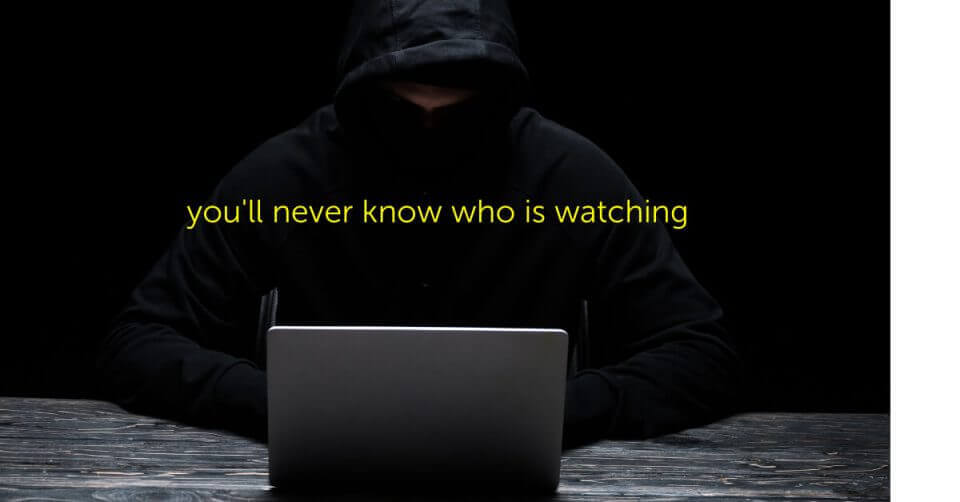 A man in a hoodie with a laptop and the importance of private DNS.