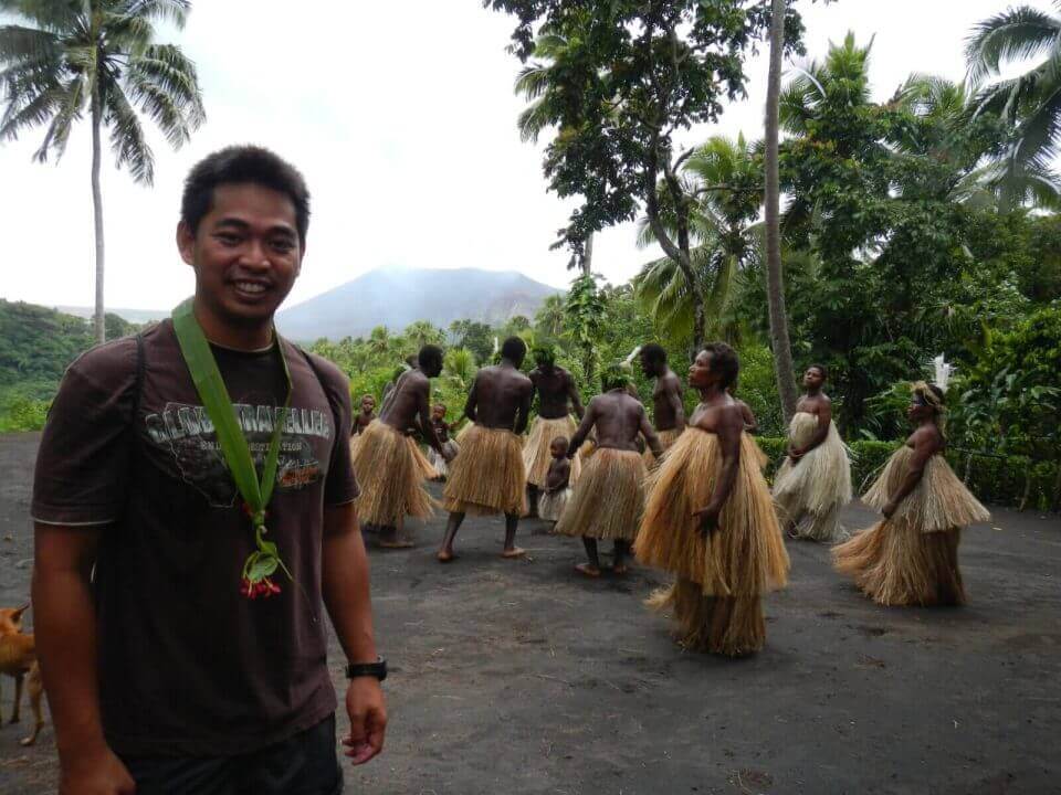 A man in grass skirt leading a group celebration.