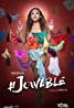 Amid a swirl of colorful bras against the red backdrop, a woman stands confidently in her green and orange attire. Her ensemble, featuring a midriff-baring top and a tied cloth skirt, exudes flair. The title "#JCVVLE" is boldly displayed below, echoing the vibrancy often seen in VivaFilms productions.