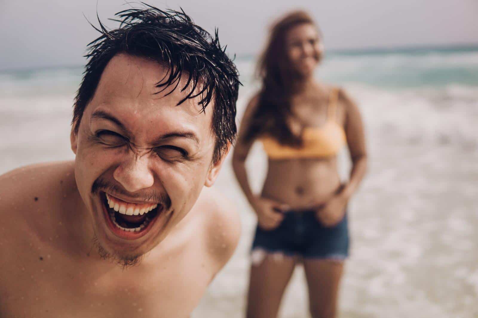 A couple enjoying a cheerful moment on the beach.