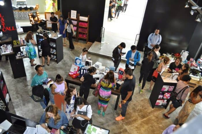 An aerial view of a crowd at an event with bargain shopping outlets.