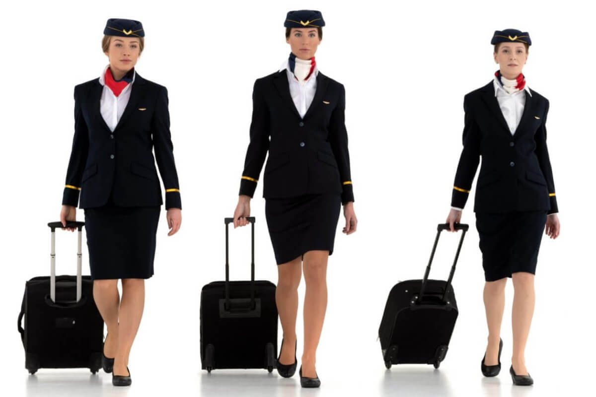 A group of Philippines airline attendants with luggage.