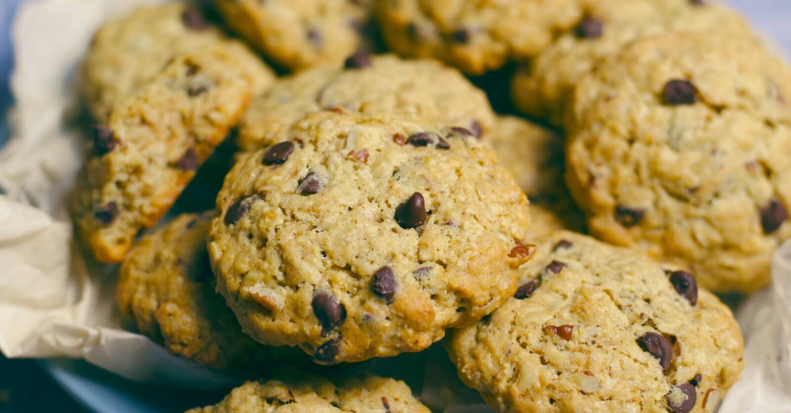 A close-up image of freshly baked chocolate chip cookies from one of Metro Manila's best cookie places, with golden edges and visible chocolate chunks, arranged on a plate lined with parchment paper.