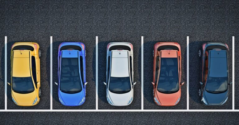 A top-down view of a parking lot shows five cars parked in a row, each in separate parking spots. The cars are, from left to right, yellow, blue, white, red, and black. The parking spots are outlined with white lines on the asphalt surface. It's a BGC designed for a stress-free experience.