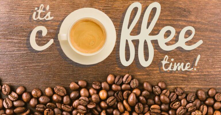 A white cup of coffee sits on a wooden surface, surrounded by scattered coffee beans. The words "it's coffee time!" are artistically written in beige lettering around the cup. The composition creates a cozy and inviting atmosphere that celebrates Antipolo's best coffee shops.