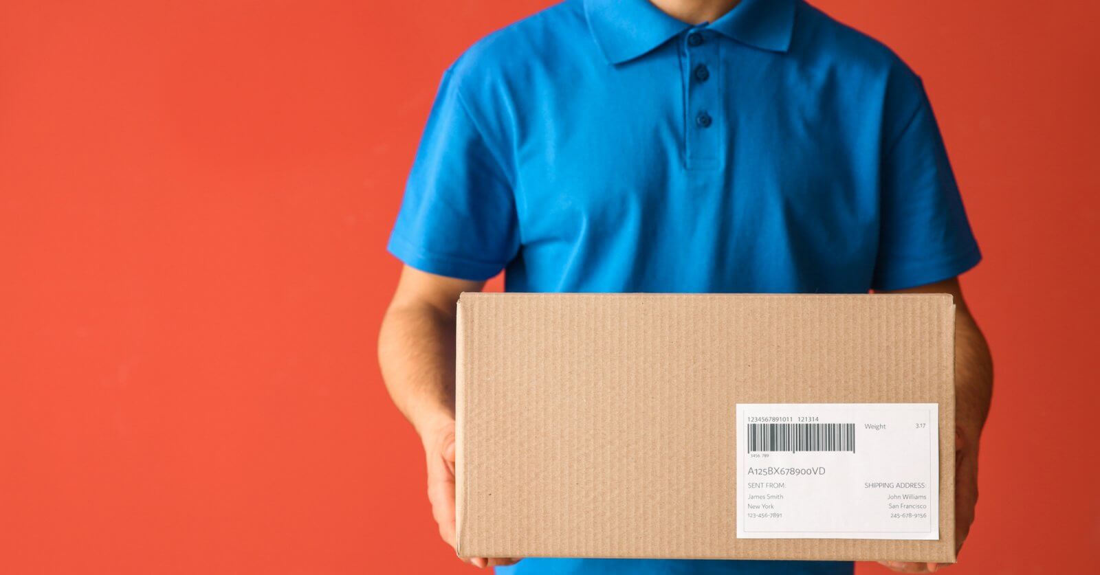 A person in a blue polo shirt holds a cardboard box with a shipping label, likely ready for delivery to a Shopee Xpress Drop-off Point. Set against a solid orange-red background, the box is centered in the image, though the text on its label isn’t fully readable. The person's head remains out of view.