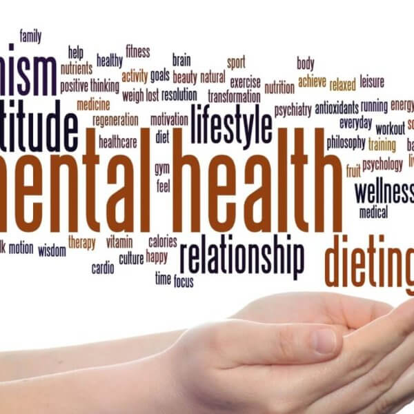 A pair of cupped hands is positioned below a floating word cloud featuring terms related to well-being, with "mental health" prominently displayed in large text. Surrounding words include "optimism," "active," "attitude," and more. This visual represents top mental health services available in Metro Manila.