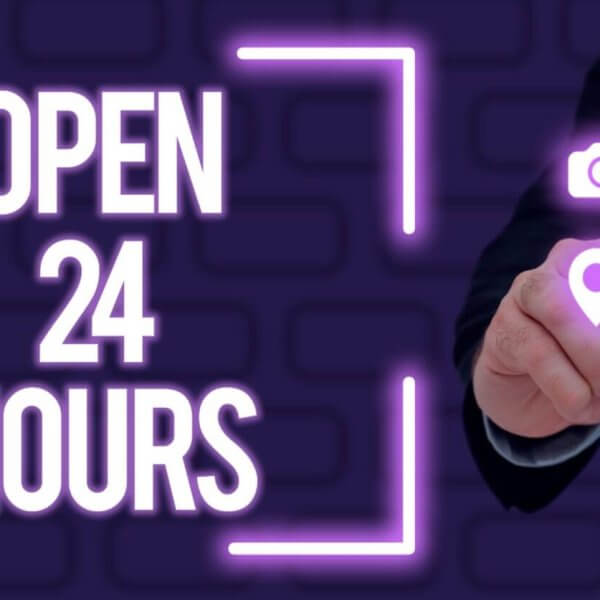 A person in a dark suit taps a glowing purple pinpoint icon on a virtual screen. Surrounding icons include a camera, bell, volume, power button, and a graphic of connected nodes. The text "24 HOUR DINING" is prominently displayed, also in purple, against a dark background with a brick pattern.