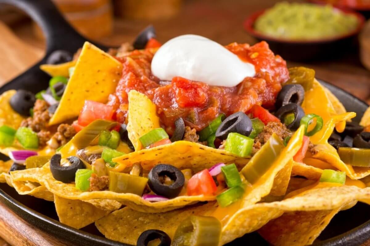 Colorful ingredients are arranged on a bed of crispy tortilla chips in a cast iron skillet at one of Bonifacio Global City's best restaurants.