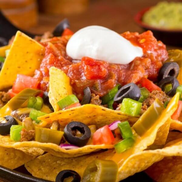 Colorful ingredients are arranged on a bed of crispy tortilla chips in a cast iron skillet at one of Bonifacio Global City's best restaurants.