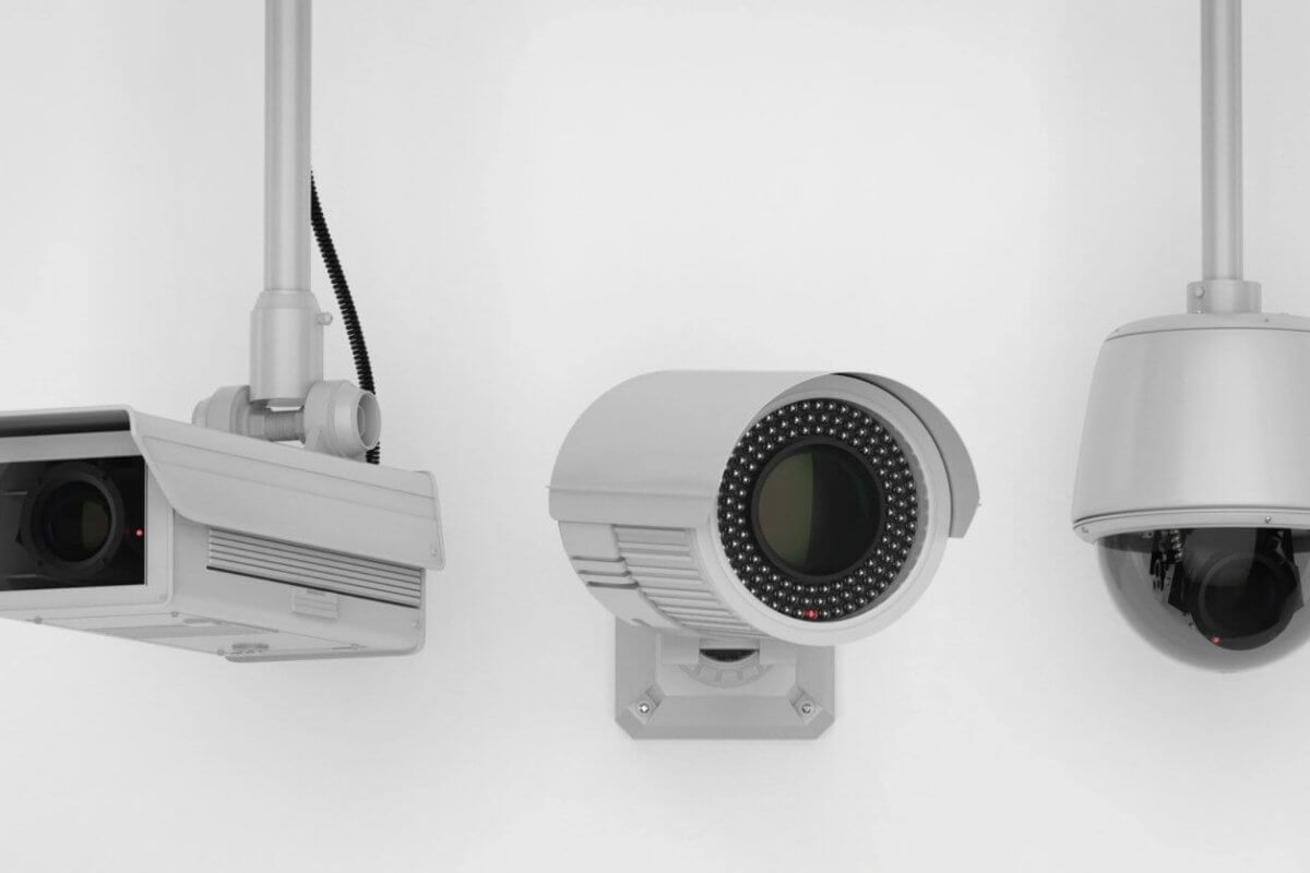 Three security cameras mounted on white walls. The leftmost camera has a rectangular housing; the one in the middle is cylindrical with an array of infrared LEDs around the lens; the rightmost camera is dome-shaped, enclosed in a transparent, spherical casing—an ideal setup by a top CCTV supplier in Metro Manila.