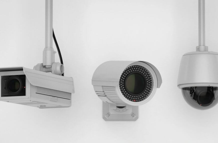 Three security cameras mounted on white walls. The leftmost camera has a rectangular housing; the one in the middle is cylindrical with an array of infrared LEDs around the lens; the rightmost camera is dome-shaped, enclosed in a transparent, spherical casing—an ideal setup by a top CCTV supplier in Metro Manila.