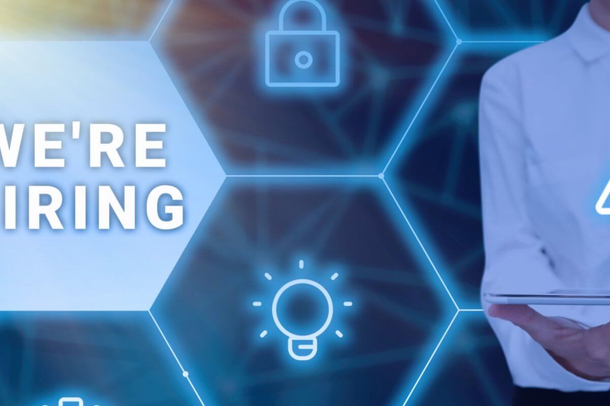 A person in a white shirt is holding a tablet and using a stylus, with a glowing network of hexagonal icons featuring a padlock, a warning sign, and a lightbulb. The text "WE'RE HIRING" is displayed prominently within one of the hexagons on the left side of the image, highlighting opportunities in Metro Manila for manpower agencies.