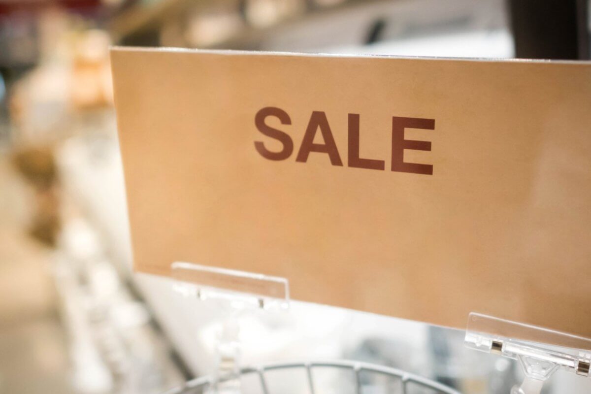 In a bustling Metro Manila outlet store, a vibrant sign reads SULIT DEAL while blurred shelves loaded with treasures sit invitingly in the background.