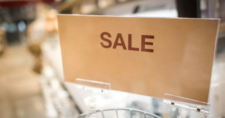 In a bustling Metro Manila outlet store, a vibrant sign reads SULIT DEAL while blurred shelves loaded with treasures sit invitingly in the background.
