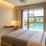 Bright budget hotel room in Metro Manila with a glimpse of an outdoor pool, representing an under-₱3,000 staycation stay
