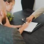 Couple signing a membership contract at a desk during a vacation club sales presentation in the Philippines