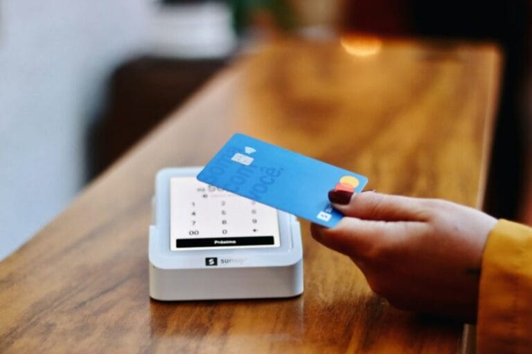 Filipino shopper holding a credit card in front of a payment terminal at a store checkout, about to choose between paying cash or taking a 0% installment plan