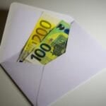 White envelope with cash bills inside, representing a 13th month pay bonus payout in the Philippines