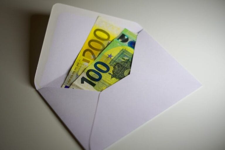 White envelope with cash bills inside, representing a 13th month pay bonus payout in the Philippines