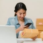 Filipino online shopper scanning a delivered product against her phone to verify it before trusting the platform — illustrating the Shopee, Lazada, TikTok Shop, Carousell, and Facebook Marketplace buyer protection comparison