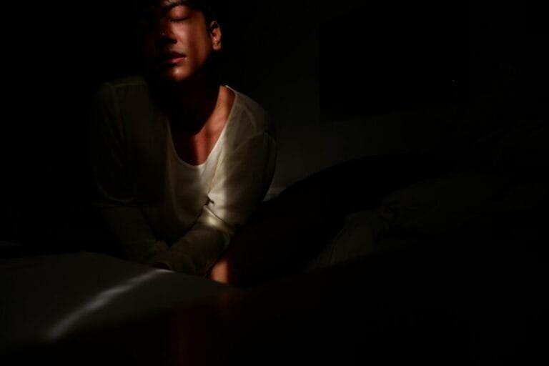 Person alone at night watching a streaming video on a smartphone in bed, illustrating the decision of whether a Vivamax (VMX) subscription in the Philippines is worth paying for