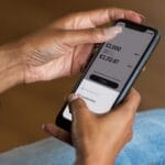 Hands holding a smartphone open to a digital bank savings app, comparing interest rates for a Philippine digital bank savings account