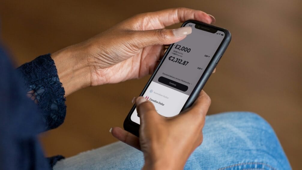 Hands holding a smartphone open to a digital bank savings app, comparing interest rates for a Philippine digital bank savings account