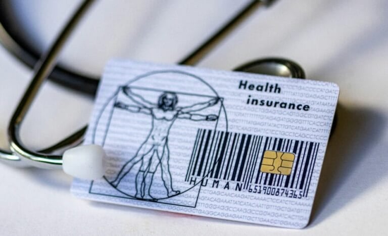 Philippine health card (HMO / health insurance card) placed next to a stethoscope, representing the choice between a basic health card and a full HMO plan in the Philippines