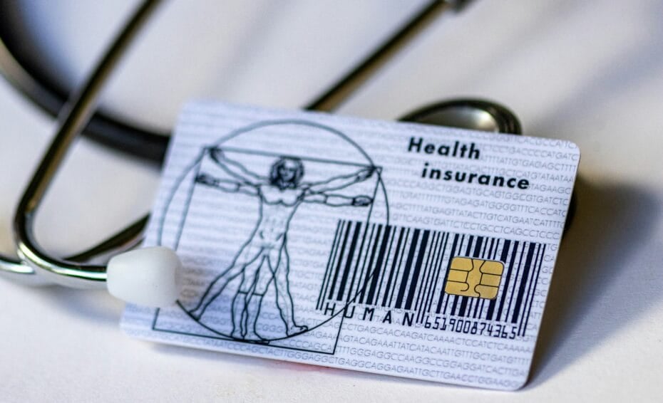 Philippine health card (HMO / health insurance card) placed next to a stethoscope, representing the choice between a basic health card and a full HMO plan in the Philippines