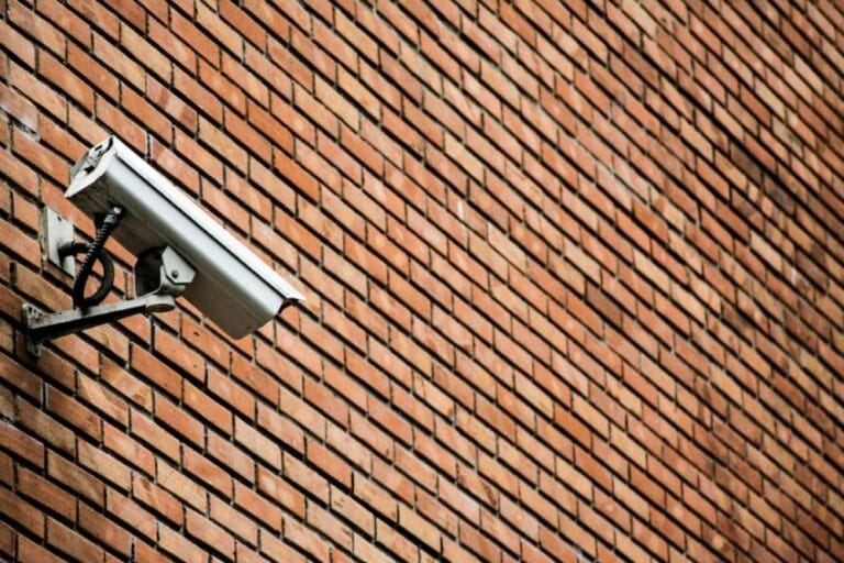 White WiFi CCTV security camera mounted on a home's brick exterior wall, the kind of home security camera setup covered in this Philippines buying guide