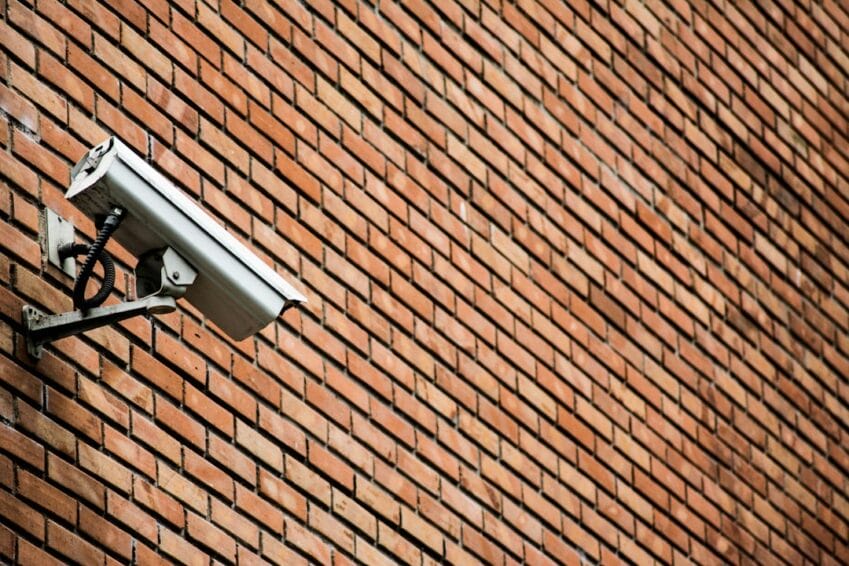 White WiFi CCTV security camera mounted on a home's brick exterior wall, the kind of home security camera setup covered in this Philippines buying guide