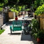 Motorcycle and tricycle parked on a residential Philippine street — the everyday ride behind the CTPL-vs-comprehensive insurance decision