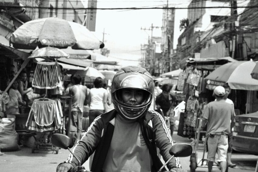 Commuter riding a motorcycle through Metro Manila traffic, the kind of everyday motorcycle purchase decided with financing in the Philippines