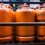 Stacked orange LPG gas cylinder tanks, the type exchanged palit-tangke style at dealers in the Philippines