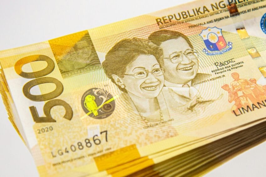 Philippine peso banknotes on a table, representing the small loan amounts covered by the SEC's 2026 online lending interest rate caps