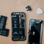 Technician closely inspecting and repairing a smartphone screen, the kind of grading check a refurbished phone goes through before resale in the Philippines