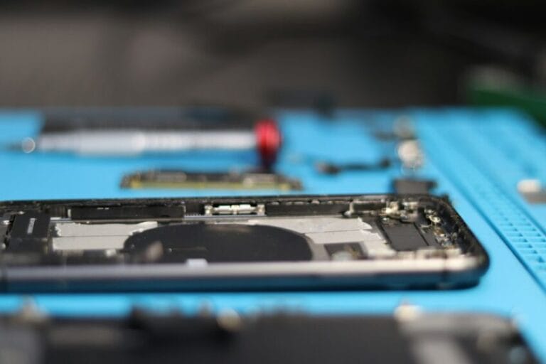 Technician disassembling an iPhone to replace parts, the kind of repair work an Apple Authorized Service Provider in the Philippines must document and warranty
