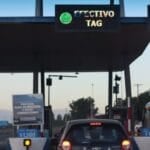 A car approaching a tollway booth lane, representing the Autosweep and Easytrip RFID toll lanes used on Philippine expressways