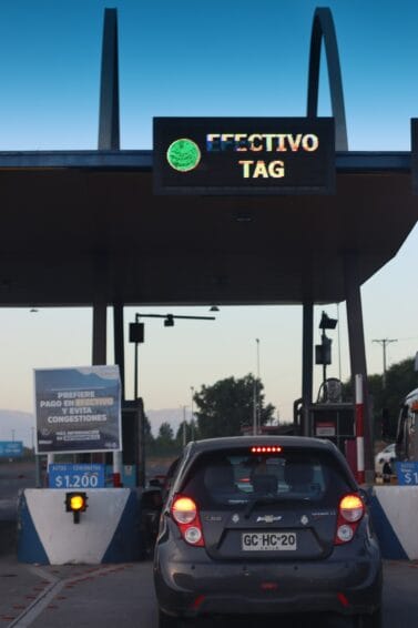 A car approaching a tollway booth lane, representing the Autosweep and Easytrip RFID toll lanes used on Philippine expressways