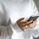 Person holding a mobile phone while checking prepaid balance