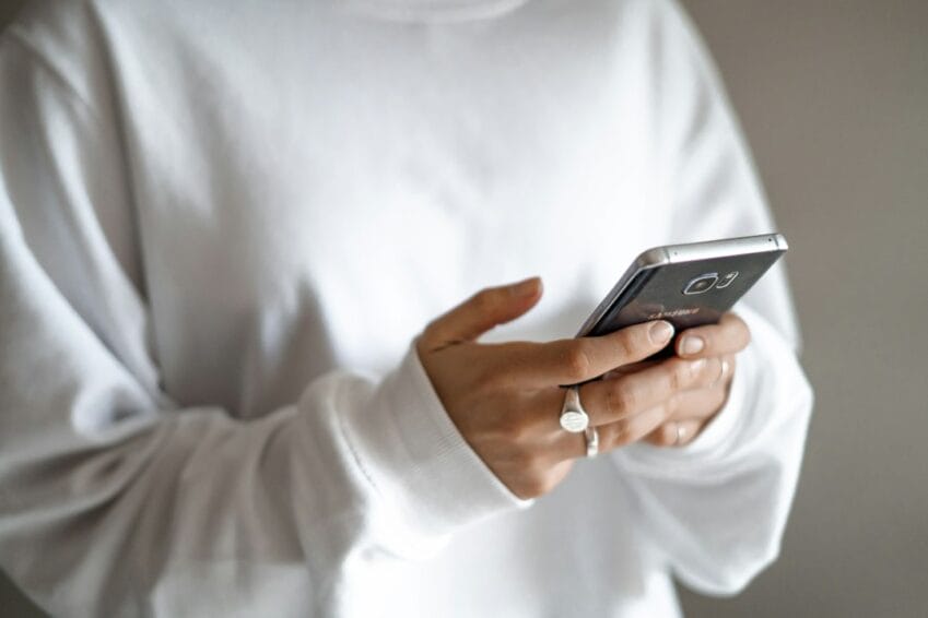 Person holding a mobile phone while checking prepaid balance