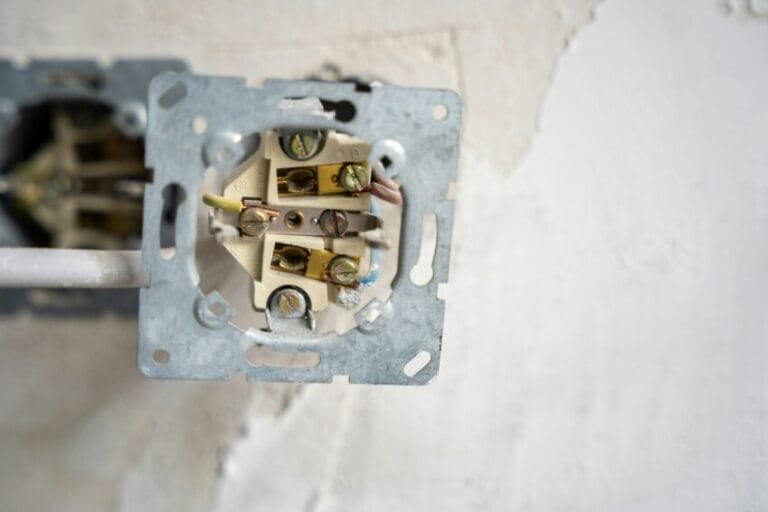 Close-up of an electrical wall outlet mid-installation with exposed color-coded wiring, the kind of grounding and wiring check needed before installing a high-wattage instant shower heater in a Philippine bathroom