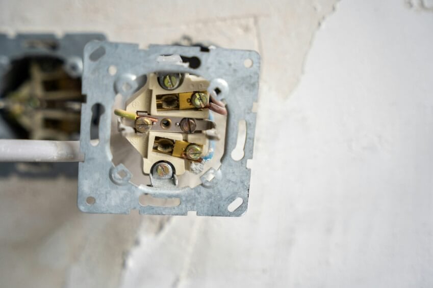 Close-up of an electrical wall outlet mid-installation with exposed color-coded wiring, the kind of grounding and wiring check needed before installing a high-wattage instant shower heater in a Philippine bathroom
