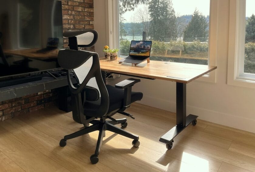 A solid wood standing desk paired with a mesh-back ergonomic office chair in a home office setup, illustrating the chair-vs-standing-desk buying decision for WFH in the Philippines