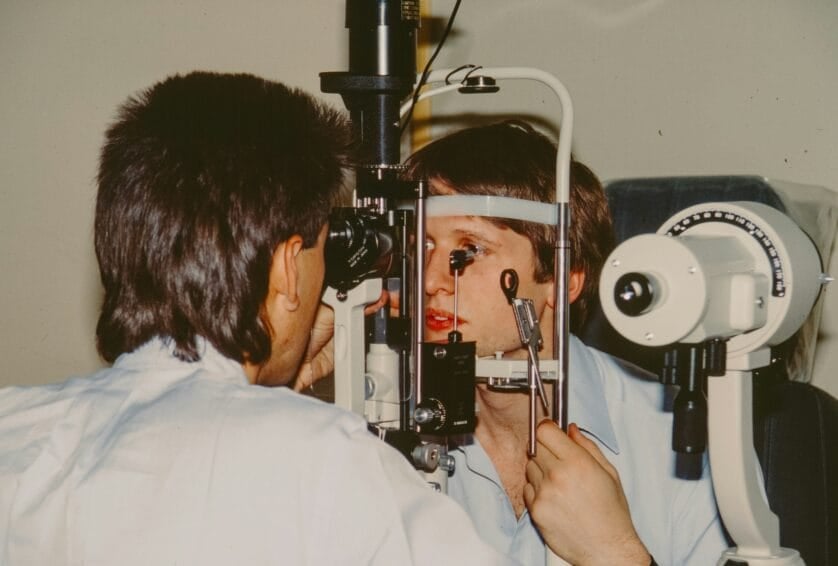 Optometrist examining a patient's eye with a slit lamp during a pre-LASIK screening exam in the Philippines