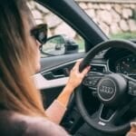 Hands gripping a car's steering wheel while driving, representing the LTO-mandated Practical Driving Course (PDC) new license applicants in the Philippines must complete