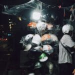Motorcycle helmets displayed for sale at a street vendor stall — buyers can't tell a genuine DTI ICC or PS certification sticker from a fake one just by looking, which is the risk this guide covers for Philippine motorcycle riders