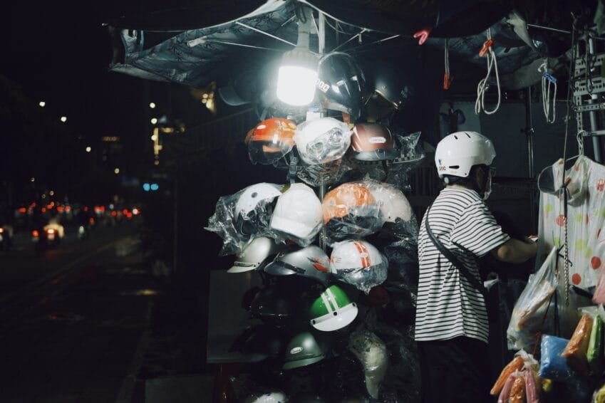 Motorcycle helmets displayed for sale at a street vendor stall — buyers can't tell a genuine DTI ICC or PS certification sticker from a fake one just by looking, which is the risk this guide covers for Philippine motorcycle riders
