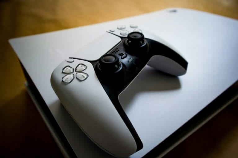 Sony PlayStation 5 console standing upright with its white DualSense wireless controller resting on top, the console now priced at ₱40,032 in the Philippines after Sony's 2026 price hike
